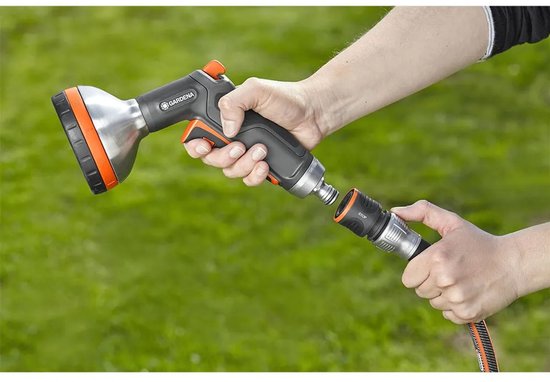 Hand met GARDENA sproeier koppelt deze aan een waterstop met oranje rand.