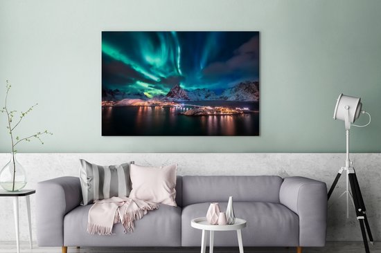 Une peinture des Lofoten avec une aurore verte et bleue au-dessus de montagnes enneigées et de maisons éclairées.