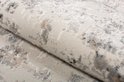 Détail de la texture douce d'un tapis gris clair au motif subtilement délavé.