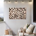 Une affiche avec des bûches empilées de différents diamètres et teintes naturelles, accrochée à un mur blanc.