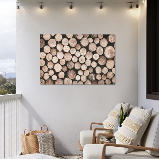 Une affiche avec des bûches empilées de différents diamètres et teintes naturelles, accrochée à un mur blanc.