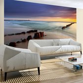 Fotobehangkoning - Behang - Vliesbehang - Fotobehang Zee en Strand met Zonsondergang - 300 x 231 cm