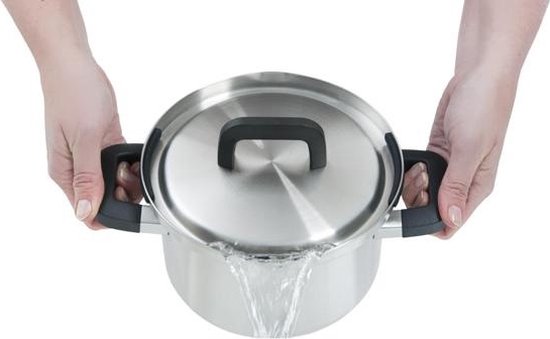 Handen houden een roestvrijstalen kookpan met zwarte handvatten vast terwijl water eruit stroomt.