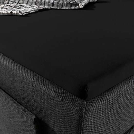 Detail van een zwart hoeslaken op een donkergrijs bed.