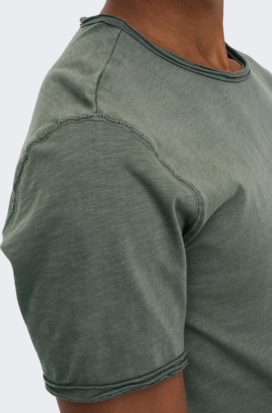 Gedetailleerde opname van de schouder en mouw van een olijfgroen T-shirt met stiksels.