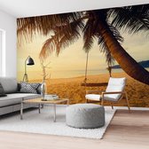 Fotobehang Strand Schommel op een palmenstrand 260x384 cm Vlies - Reinders