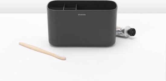 Donkergrijze tandenborstelhouder met Brabantia logo, naast een bamboe tandenborstel en tube tandpasta.