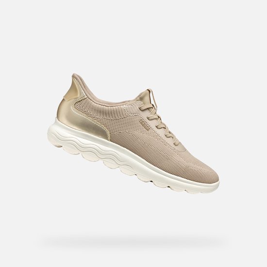 Sneaker Geox beige clair avec détails dorés, en lévitation.