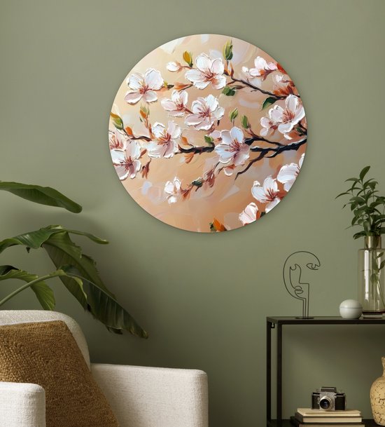 Wandcirkel met schilderachtige roze bloesemtakken, hangend aan een groen geschilderde muur.