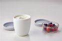Witte lunchpot met yoghurt en een apart compartiment met bessen.