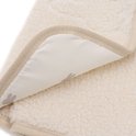 Close-up van een crèmekleurige teddy verschoonmat met beige rand. De binnenkant toont een Nijntje print.