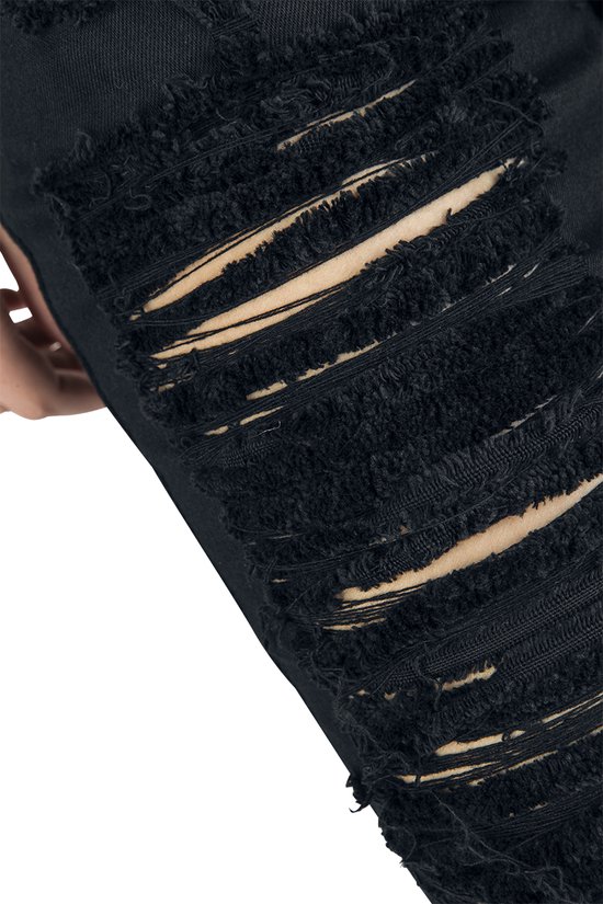 Close-up van zwarte shorts met zwaar beschadigde, rafelige scheuren die de huid laten zien.