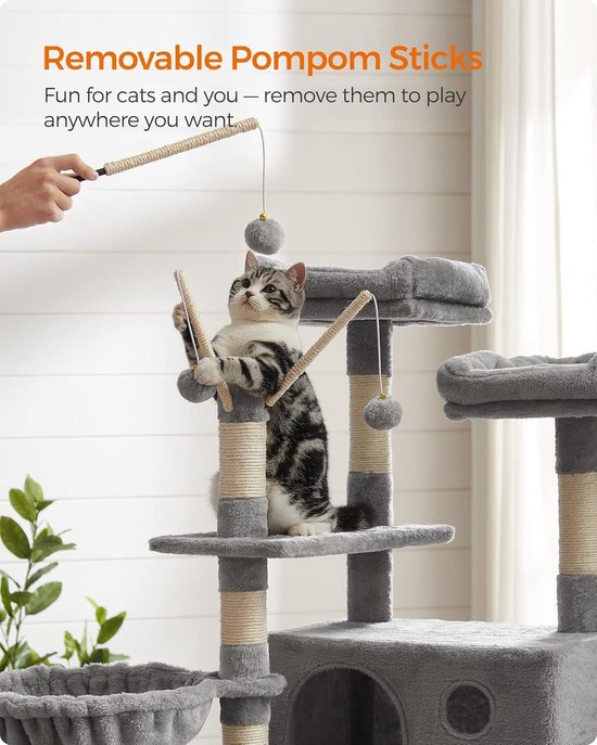 Grijze kattenboom met grijze pluizenbollen aan touwtjes, een kat speelt met twee stokjes.