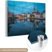 MuchoWow® Glasschilderij 180x120 cm - Schilderij acrylglas - Havengebied van Lübeck in de avond - Foto op glas - Schilderijen