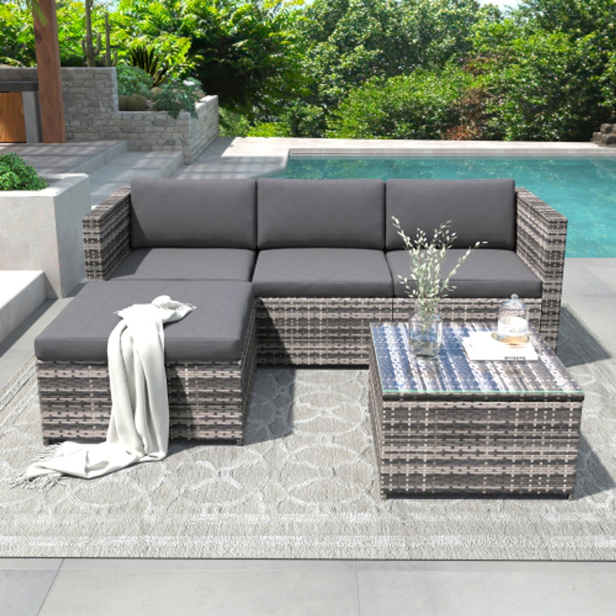 Polyrattan loungebankset in grijs met zit- en rugkussens, loungetafel met glazen blad.