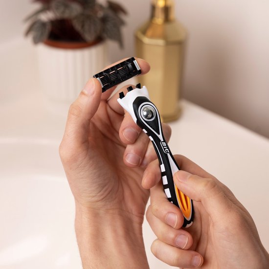 Mains masculines changeant une tête de rasoir à 5 lames en titane sur un rasoir BIC Hybrid 5 Flex noir, blanc et orange.