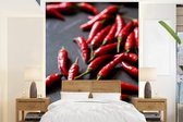 Behang - Fotobehang Rode cayennepepers op grijze ondergrond - Breedte 165 cm x hoogte 220 cm