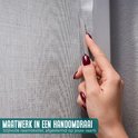 Hand met donkere nagellak knipt grijze, textielachtige raamfolie op maat. "Maatwerk in een handomdraai".