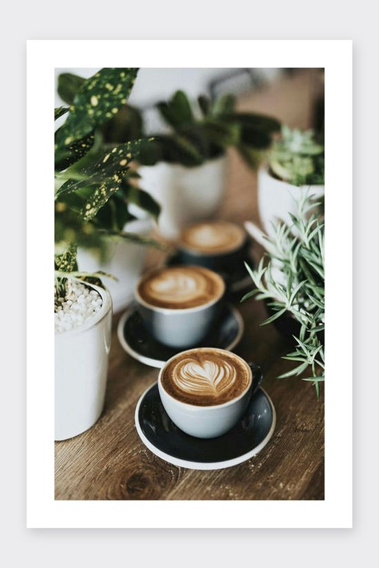 Drie koppen koffie met latte art, omringd door planten.