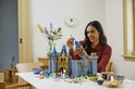 Een vrouw bouwt het LEGO Disney Kasteel, ze houdt een toren-onderdeel vast, klaar om te plaatsen.