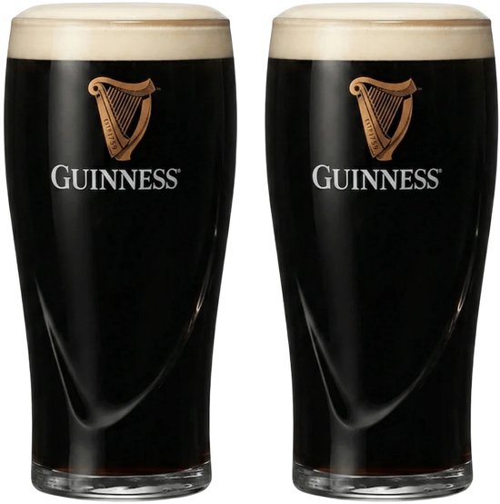 Deux verres à pinte Guinness pleins avec de la mousse, chacun avec le logo doré de harpe.
