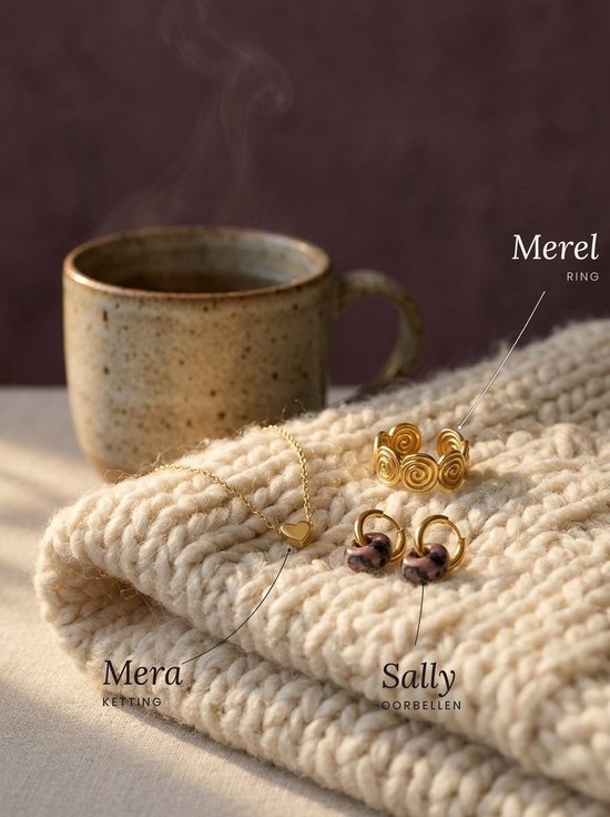 Gouden Merel ring met spiraalmotief, Mera ketting met hartje en Sally oorringen met roze steen op een gebreide trui.