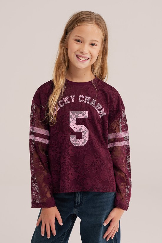 Meisje draagt een bordeauxrood kanten T-shirt met 'LUCKY CHARM 5' en sportieve mouwdetails.