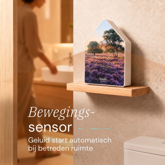 Melodiez geluidshuisje met bewegingssensor op een houten plank in een badkamer.