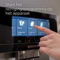 Vinger die het reinigingsprogramma op het touchscreen van de Siemens-machine selecteert. Tekst: Start het reinigingsprogramma.