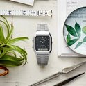 Casio horloge met zilverkleurige stalen band, vierkante zwarte wijzerplaat, analoge wijzers en digitaal display.