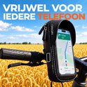 Zwarte ORIGIN telefoonhouder met zonnevizier op een fietsstuur, met navigatie op de telefoon in een veld.