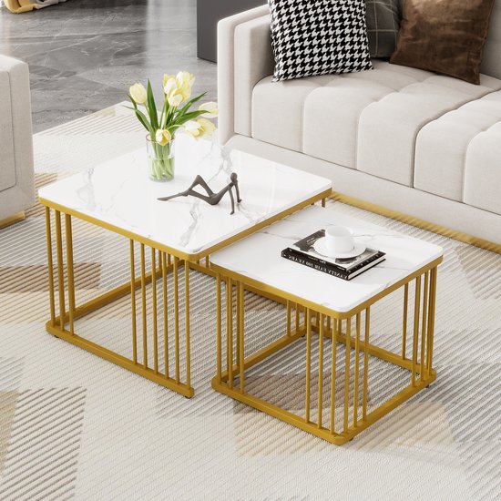 Set van twee vierkante salontafels met wit marmerlook blad en gouden spijlenframe op een tapijt.