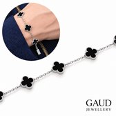 Zilveren armband van Gaud met vijf zwarte klavervormige bedels, gedragen om een pols bij een blauw jasje.