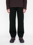 Close-up van een zwarte joggingbroek op een model, gecombineerd met bruine laarzen.