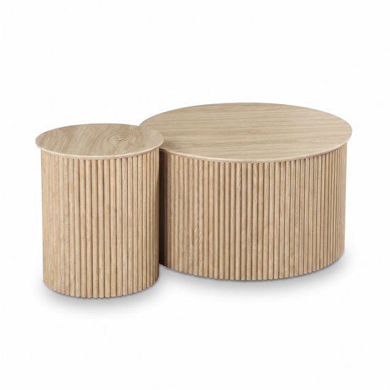 Twee ronde eikenhouten salontafels van verschillende hoogtes met een gestreept, geribbeld ontwerp.