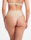 Beige high-waist string van gladde, naadloze stof, gezien van achteren op een model.