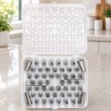 Een witte, kunststof bewaarkist met 55 metalen spuitmondjes voor het versieren van taarten en cupcakes.