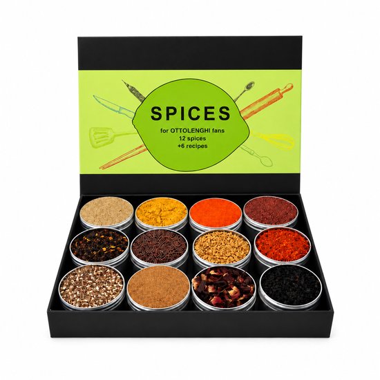 Open zwarte doos met 12 blikken kruiden in verschillende kleuren, met 'SPICES for OTTOLENGHI fans' op de deksel.