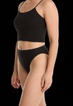 Model in een zwart hemdje en bijpassende zwarte slip met Ten Cate-logo op de tailleband.