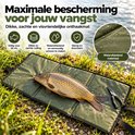 Waterafstotende olijfgroene onthaakmat met karper erop bij de waterkant.
