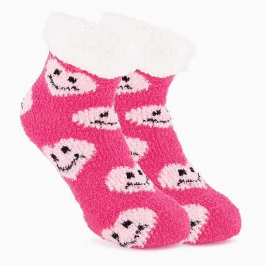Zijaanzicht van roze, pluizige kindersokken met een wit, harig boord en een patroon van lachende hartjes.