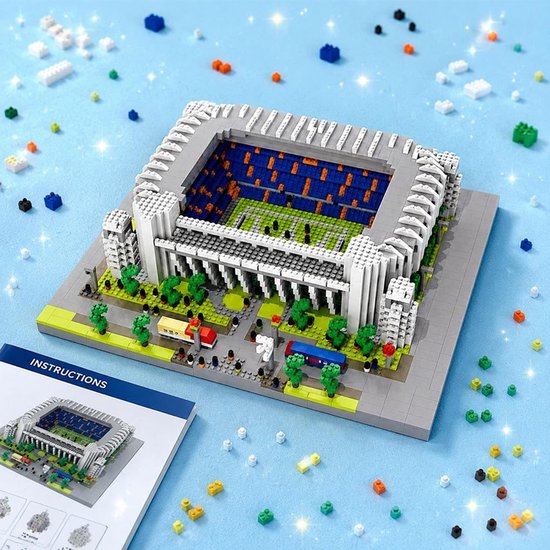 Bernabéu stadion bouwmodel op een blauwe ondergrond met een instructieboekje en losse bouwstenen.