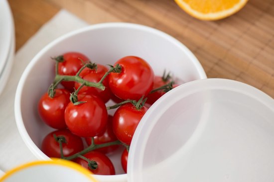 Verse tomaten in een witte kom met deksel.