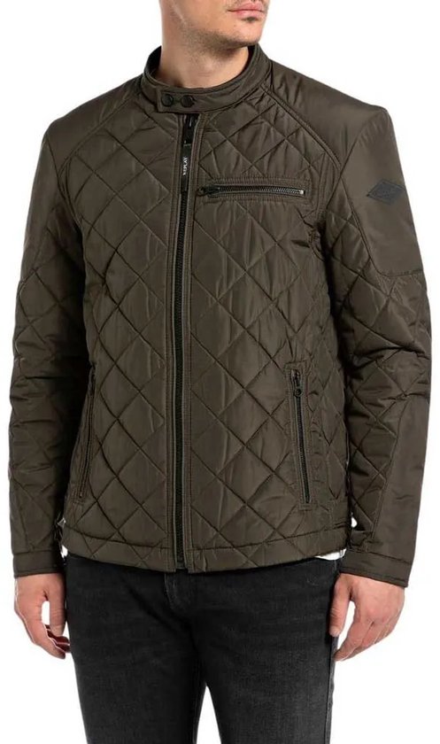 Homme portant une veste matelassée vert foncé Replay avec fermeture éclair et motif en losanges, avec un jean noir.