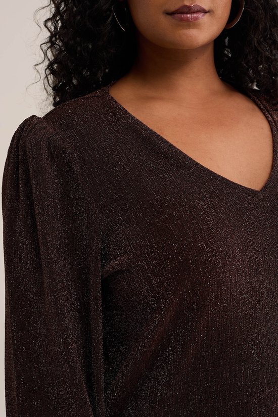 Close-up van een model in een bruine glittertop met V-hals en pofmouwen.
