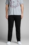 Man met grijze T-shirt en zwarte jeans, staand.