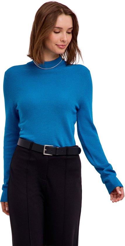 Model in blauwe coltrui en zwarte broek met riem.