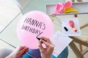 Roze ballon met tekst "Hanna's Birthday", met een Edding 400 stift die de tekst aanbrengt.