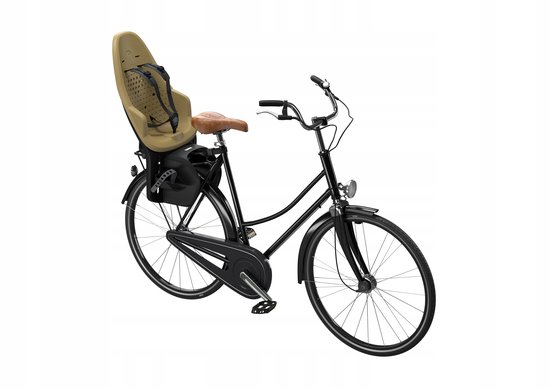Vélo noir avec selle en cuir marron et siège enfant de couleur sable avec sangles noires.
