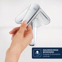 Hand die de hendel van een chroom bidetkraan beweegt voor nauwkeurige bediening.